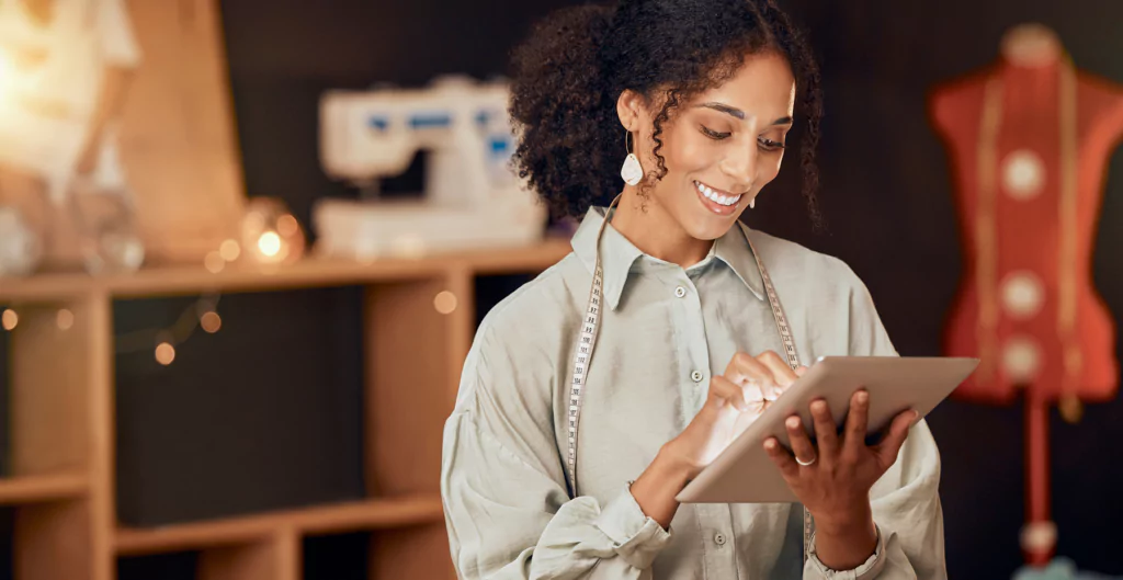 Mulher sorrindo mexendo em um tablet.