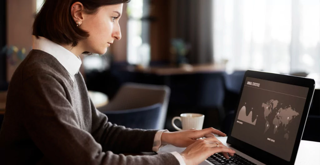 imagem mostra mulher sentada de frente para um notebook 