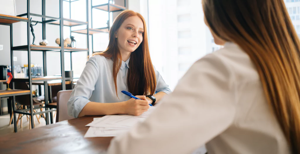 mulheres conversando e anotando informações