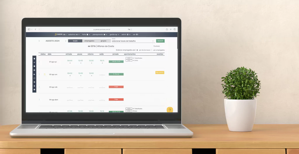 Imagem mostra a folha de ponto automatizada da pontotel aberta em um notebook. Ao laado, um vaso de planta 