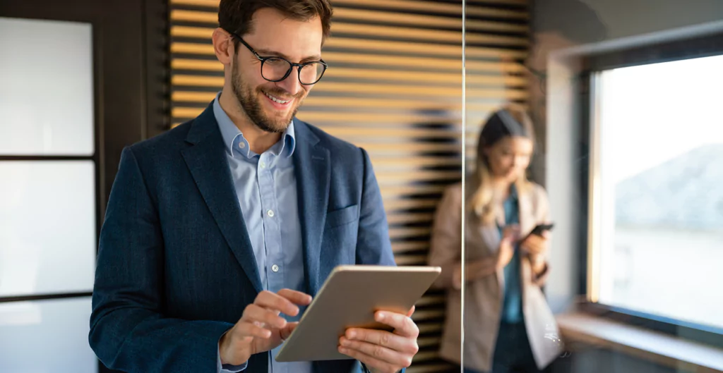 homem sorridente mexendo em um tablet 