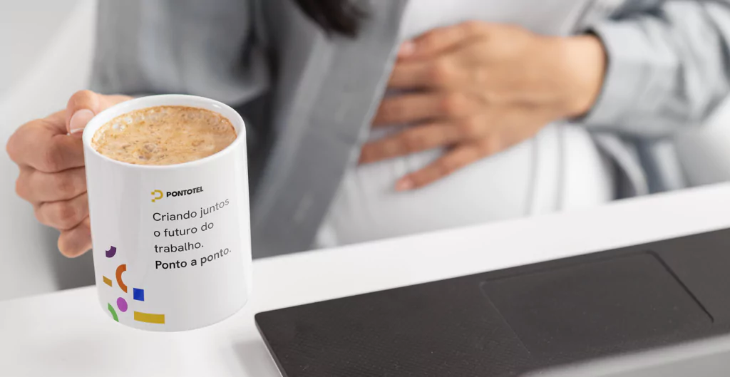 pessoa segurando uma caneca em um ambiente de trabalho