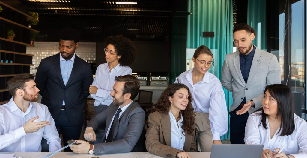 Grupo de profissionais em reunião de equipe discutindo projetos em um escritório.