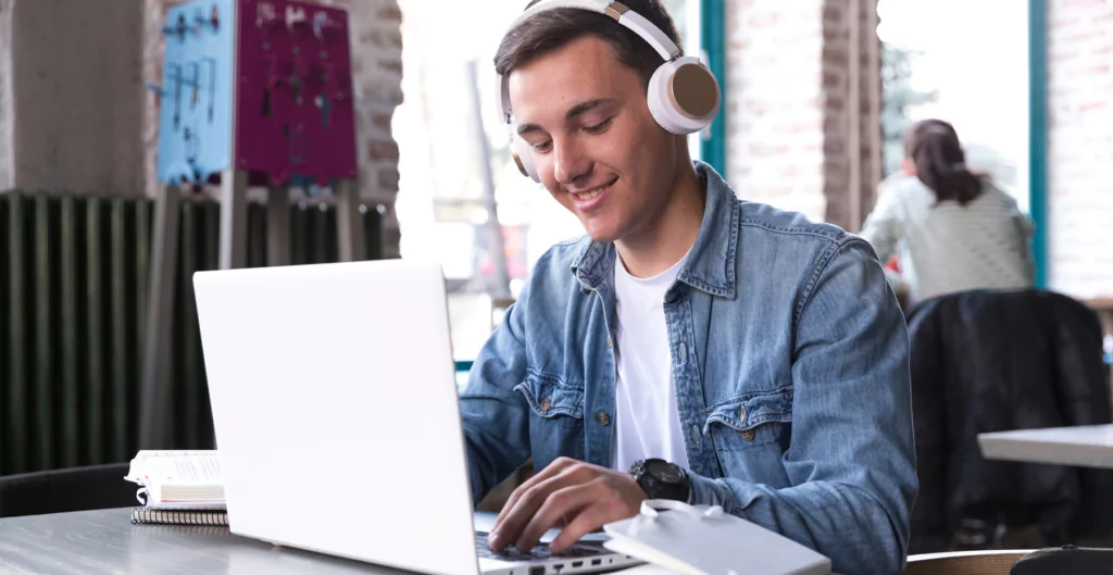 Homem utilizando notebook e fone estudando em curso ead para empresas 