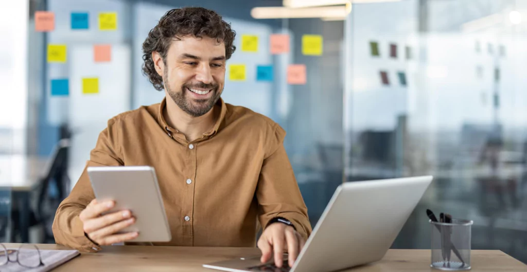 homem sorrindo segurando um tablet