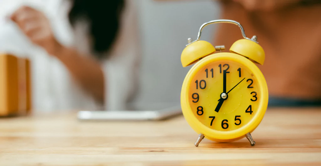 Relógio amarelo simbolizando controle de tempo e gestão de horas.