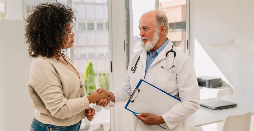 Médico cumprimentando paciente em consulta, com foco na análise de benefícios como o Atestmed.