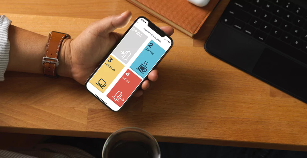 Mão segurando celular com aplicativo de ponto, ilustrando tecnologias nas relações de trabalho.