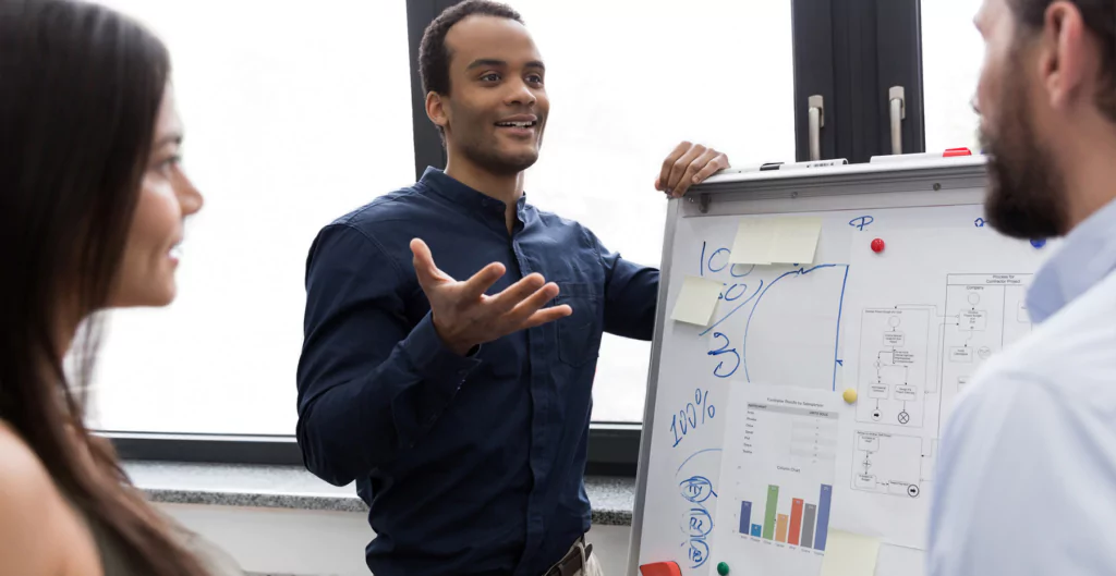 três pessoas conversando em um ambiente corporativo 