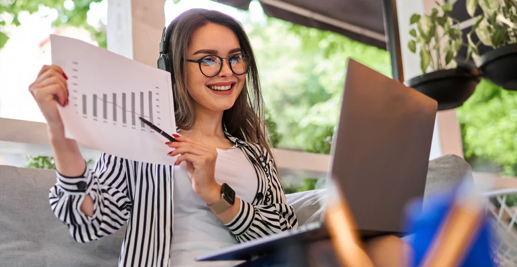 mulher sorrindo segurando um papel com um gráfico. Imagem representa profissões em alta 2025