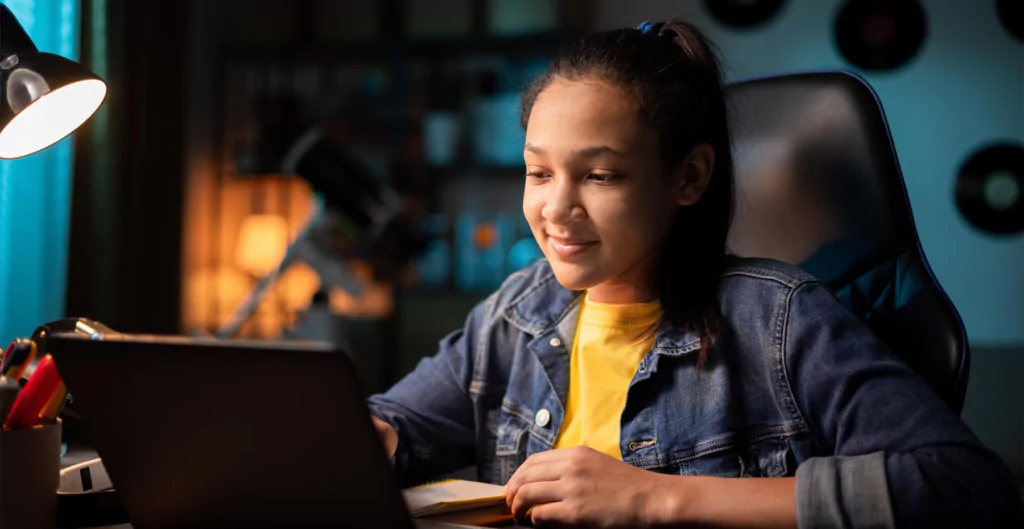 Jovem aprendiz estudando no computador à noite, destacando a importância do controle de ponto digital.