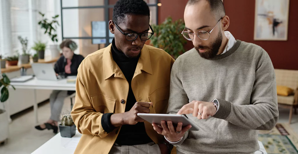 homens analisando algo em um tablet, representando as ferramentas para otimizar a rotina do rh