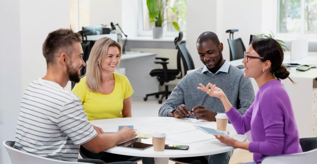 Pessoas conversando em uma mesa redonda em um escritório 