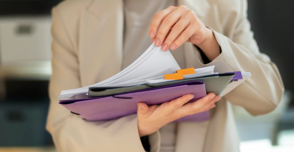 Profissional revisando arquivos organizados, simbolizando auditoria de um órgão fiscalizador.