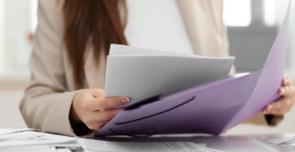 imagem de uma mulher segurando documentos, representando o TRCT