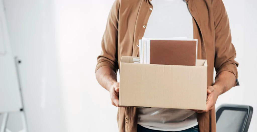 imagem de uma pessoa segurando uma caixa com itens de trabalho, representando o TRCT