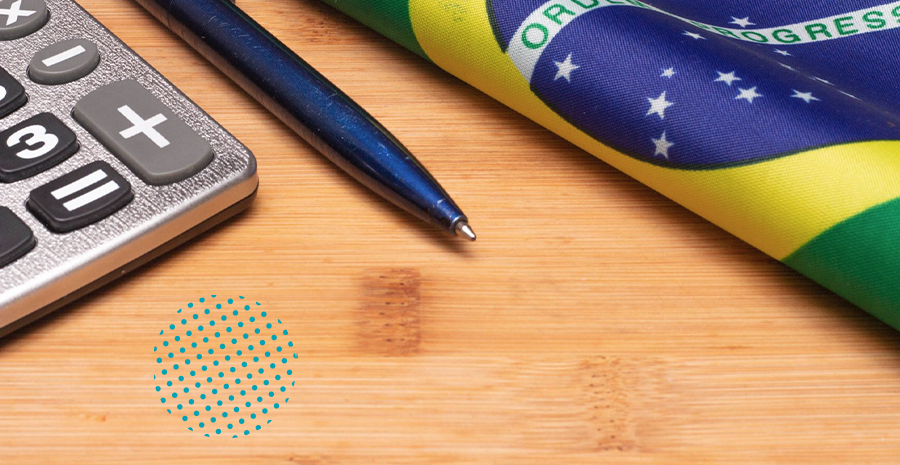 Uma calculadora, caneta e bandeira do Brasil